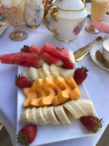 a plate with fruit and waffles and strawberries on a table at Hotel Pousada Irmaos Freyhardt in Rio de Janeiro