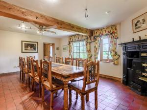 uma sala de jantar com uma mesa e cadeiras e uma lareira em Psalter Farmhouse em Skendleby