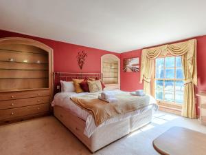 um quarto com uma cama grande e paredes vermelhas em Psalter Farmhouse em Skendleby