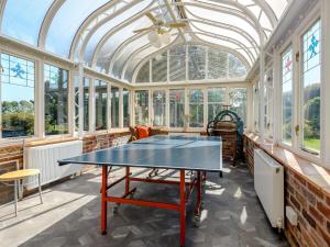 a room with a ping pong table in a conservatory at Psalter Farmhouse in Skendleby