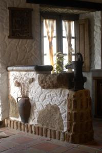 una pared de piedra con una ventana y una planta en ella en Casa Rural Margarita II, en Montánchez
