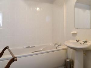 a white bathroom with a sink and a tub and a toilet at Culpee House in Newton Stewart