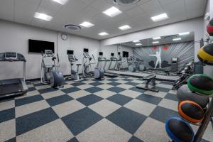 un gimnasio con cintas de correr y máquinas de ejercicio en una sala en GLō Best Western Lexington en Lexington