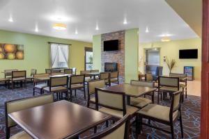 a dining room with tables and chairs and a fireplace at Best Western Plus Covered Bridge Inn in Brazil