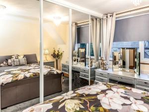 1 dormitorio con 2 camas y un espejo grande en Little Palm House en Reigate