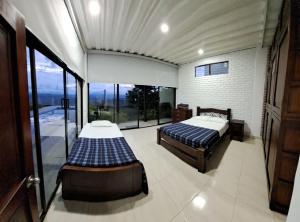 2 camas en una habitación con ventanas grandes en VILLA CARO en Palestina