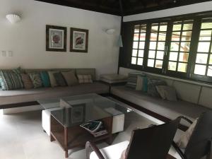 a living room with a couch and a coffee table at Casa Thai in Praia do Forte