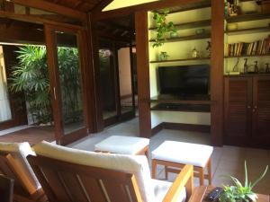 プライア・ド・フォルテにあるCasa Thaiのテレビと椅子が備わるポーチのスクリーン