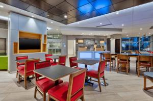 a restaurant with tables and chairs and a tv at Holiday Inn Express & Suites Jersey City - Holland Tunnel, an IHG Hotel in Jersey City