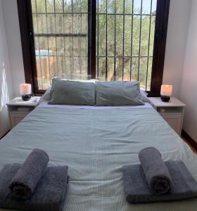 a bedroom with a bed with two towels on it at Casa Rural Las Angosturas (Caminito del Rey) in El Chorro +16 photos