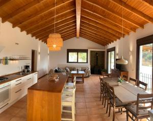 uma cozinha e sala de estar com mesa e cadeiras em Casa Rural Las Angosturas (Caminito del Rey) em El Chorro