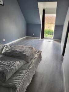 1 dormitorio con 1 cama y suelo de madera en Location 30 personnes 
