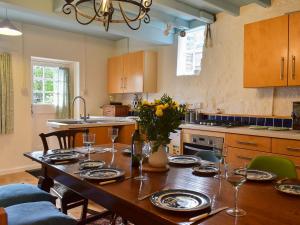 a kitchen with a wooden table with plates and wine glasses at Rosslyn House in Robin Hood's Bay