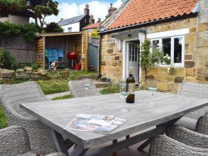 a wooden table with wine glasses on a patio at Rosslyn House in Robin Hood's Bay