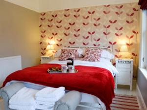 a bedroom with a red bed with a red blanket at Beech Cottage in Scalby