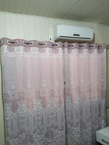 uma cortina de chuveiro na casa de banho com uma luz em Cantinho da Tete em São Francisco de Paula