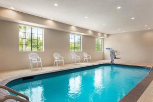 a pool in a house with chairs around it at Days Inn & Suites by Wyndham Greater Tomball in Tomball