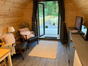 een woonkamer met een glazen schuifdeur bij Loch Ness Woodland Pods in Drumnadrochit