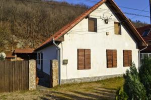 a white house with a wooden fence in front of it at Casa Sasca Montana in Sasca Montană