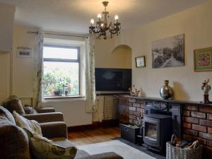 a living room with a brick fireplace and a window at Carters Rest - Uk30884 in Abererch