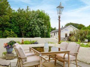 a patio with a table and chairs and a fountain at Carters Rest - Uk30884 in Abererch