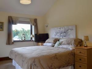 a bedroom with a large bed and a window at Carters Rest - Uk30884 in Abererch
