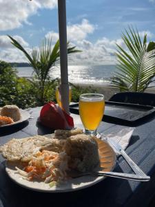 een tafel met een bord eten en een glas sinaasappelsap bij El Retoño del Negro Gozón in Nuquí