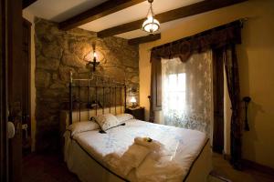 un dormitorio con una cama con un animal de peluche en CASA RURAL MARGARITA I, en Montánchez
