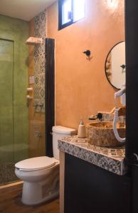 a bathroom with a toilet and a sink and a mirror at Habitaciones Colonial Zaci in Valladolid