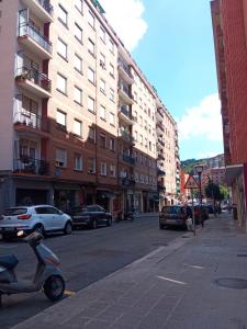 une rue avec des voitures garées sur le côté de la route dans l'établissement Habitación 1 con vistas, à Bilbao