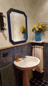 a bathroom with a sink and a mirror and flowers at Casa Rosi - Loft tra i monti di Roccaraso in Rionero Sannitico