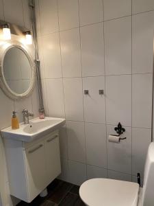 a bathroom with a sink and a toilet and a mirror at Villa Gasabäck in Söråker