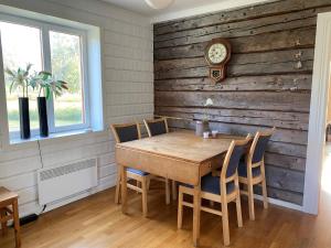 a dining room with a table and a clock on a wall at Villa Gasabäck in Söråker