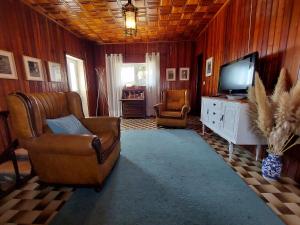 uma sala de estar com um sofá e uma televisão em Casa do Sobrado Arouca em Arouca