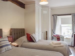 two beds sitting next to each other in a bedroom at Cam Cottage in Kettlewell