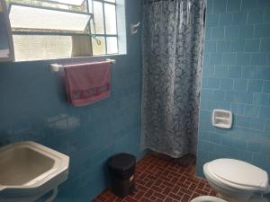a blue tiled bathroom with a toilet and a sink at Rancho dante restaurante e pousada in Belmiro Braga
