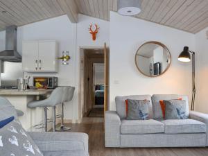 uma sala de estar e cozinha com um sofá e um espelho em Cruachan em Etteridge