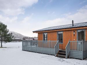 une cabine avec une terrasse dans la neige dans l'établissement Cruachan, à Etteridge