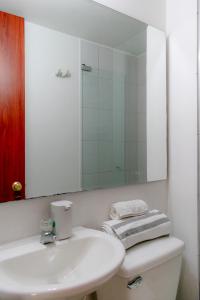 uma casa de banho branca com um lavatório e um espelho em EXPECTACULAR APARTAMENTO OPORTUNOx em Bogotá