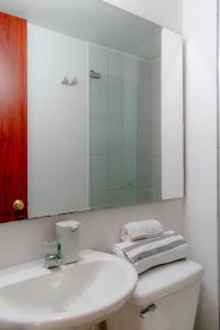Un baño blanco con lavabo y espejo. en EXPECTACULAR APARTAMENTO OPORTUNOx, en Bogotá