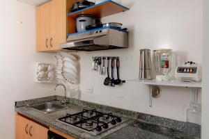 波哥大的住宿－EXPECTACULAR APARTAMENTO OPORTUNOx，厨房配有水槽和炉灶 顶部烤箱