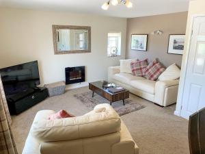 a living room with two couches and a television at The Paddock in Bodelwyddan