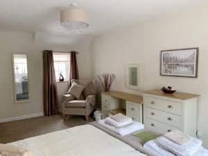 um quarto com uma cama, uma secretária e uma cadeira em The Paddock em Bodelwyddan