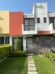 uma casa colorida com um relvado em frente em Punta del Sol Catarinas em Temixco