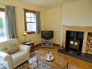 a living room with a white couch and a fireplace at The Bothy in Haywood