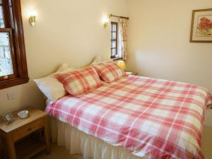 a bedroom with a bed with a checkered blanket at The Bothy in Haywood