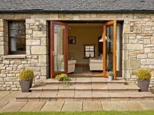 Casa de piedra con puerta y porche en The Bothy, en Haywood
