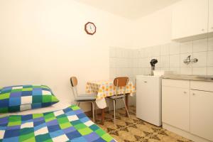 1 dormitorio con cama, mesa y cocina en Studio Brsec 2359a, en Brseč