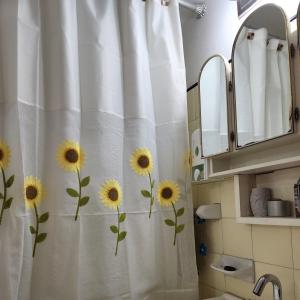 a bathroom with a shower curtain with sunflowers on it at Ana Dpto in Mar del Plata
