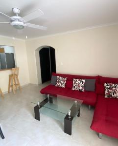 a living room with a red couch and a table at Apartamento Rodadero in Gaira